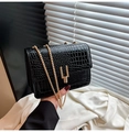 Détail du sac noir texture crocodile avec chaîne dorée et fermoir métallique en U - Noir