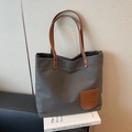 Dark grey canvas tote bag with brown leather straps on a white book and leather sofa - Dark Brown