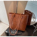 Detailed macro view of dark brown leather bucket bag with glossy oil finish and slim straps - Brown