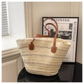 Detailed view of woven straw tote bag texture with reinforced brown leather handles - Off White