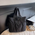 Black nylon tote bag with drawstring pockets and wide strap in minimalist workwear style - Black