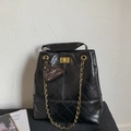 Close-up of black quilted leather bucket bag with golden twist lock and chain strap - Black (With Pendant)