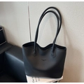Detalle de la textura de lichi y las letras grabadas en el bolso tote negro - Negro
