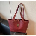 Nahaufnahme der weinroten Shopper-Tasche mit goldener Schnalle auf Lifestyle-Hintergrund - Rot