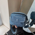 Minimalist light blue denim crossbody bag featuring a front pocket with silver metal button - Light Blue