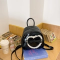 Süßer schwarzer Leder-Minirucksack mit weißem Spitzenherz und Schleife im Bücherregal - Schwarz