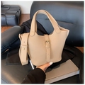 Détail du sac seau beige à texture litchi avec boucles dorées et large bandoulière - Kaki