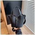 Gros plan sur un sac seau noir en cuir grainé avec boucle en métal doré élégante - Noir