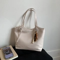 Detail of beige tote bag with faux leather texture and bohemian wooden bead charm - White with Pendant