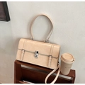 Bolso bandolera beige minimalista con hebilla metálica y asa sobre estante de madera - Caqui