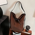 Dunkelbraune Wildleder-Beuteltasche mit schwarzer Lederschleife und schmalem Gurt - Braun