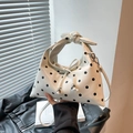 Chic cream dumpling bag with black polka dots, featuring a top handle and silver hardware - White