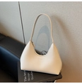Detalle del bolso hobo de cuero granulado blanco roto sobre libros de diseño - Blanco