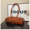 Close-up of caramel brown glossy wrinkled leather shoulder bag with golden buckle details - Brown