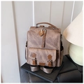 Dettaglio di zaino vintage in similpelle marrone con cinturini su sedile in pelle - Marrone
