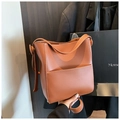 Detail of a brown bucket bag with contrast stitching and adjustable shoulder strap - Brown