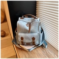 Dettaglio dello zaino vintage azzurro sul davanzale in legno con luce naturale - Blu