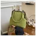 Detailopname van groene suède schelptas met vintage metalen sluiting en handvatdetails - Groen