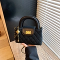 Borsa trapuntata nera con catena dorata e ciondolo a sfera in un ambiente di tendenza - Nero