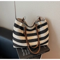 Détail du sac cabas tissé à rayures avec bandoulière en cuir marron et chaîne métallique - Noir