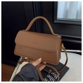 Detailed shot of brown vintage shoulder bag featuring a sleek flap and top handle - Brown