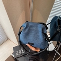 Bolso tipo cubo de denim azul con asa espiral negra y detalle de etiqueta cuero - Negro