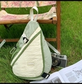 Dettaglio della borsa a tracolla in nylon leggero verde chiaro e crema sull'erba - Verde