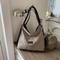 Detail of khaki frosted suede bucket bag featuring black leather straps and fashion label - Khaki