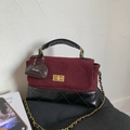 Detail of burgundy and black quilted handbag with gold clasp and chain strap - Red with Pendant