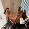Brown vintage faux leather hobo bag with silver eyelets and plush dog charm accessory - Brown with Pendant