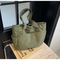 Retro bean green corduroy tote bag with multiple pockets on a stone background - Green