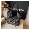 Detail view of leopard print tote bag with large black leather bow and shoulder straps - Black