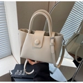 Detailed close-up of cream-colored lychee leather texture on a designer bucket handbag - Off-white