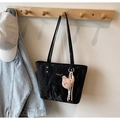 Nahaufnahme der schwarzen Tote Bag aus Knitterleder mit Golddruck und Bären-Anhänger - Schwarz mit Anhänger