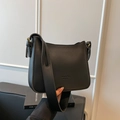 Bolso tipo cubo negro minimalista con correa ancha y detalles metálicos dorados - Negro