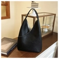 Detail of black leather hobo bag featuring unique crinkled texture and asymmetric front pocket - Black