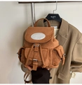 Macro shot of brown suede backpack with vintage multi-pockets and drawstring closure - Brown