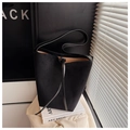 Detail of minimalist black suede bucket bag featuring smooth leather handles and drawstring - Black