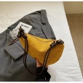 Détail du sac demi-lune jaune en daim avec bandoulière à nœuds sur un blazer gris - Jaune