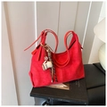 Dettaglio di una borsa tote grande in camoscio rosso con ciondolo COFFEE e manici - Con Ciondolo / Rosso