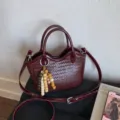 Nahaufnahme gewebte weinrote Handtasche mit Vintage-Perlenquaste und Trageriemen - Burgunderrot