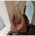 Detailed view of the dark brown woven texture and wide shoulder strap on this hobo tote - Brown