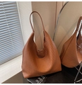 Detail of a brown woven leather tote bag with soft texture and minimalist hobo shape - Brown