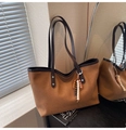 Detail of retro canvas tote bag with brown leather handles and wooden bead tassel - Brown