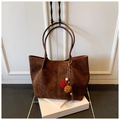 Detail of dark brown faux suede tote bag with decorative tassel and plush pom poms - Brown