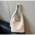 Detail der cremefarbenen geflochtenen Hobo-Tasche mit breitem Gurt und goldener Schnalle - Cremeweiß