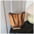 Macro shot of vintage suede bucket bag with brown leather details on a minimal bench - Brown