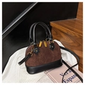 Detail of retro coffee brown quilted shell bag with contrast black handles and gold hardware - Brown
