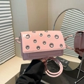 Pink glossy retro crossbody bag with decorative silver metal eyelets and round strap - Pink