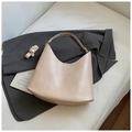 Minimalist beige hobo shoulder bag in matte leather style on a white sofa scene - White Without Pendant